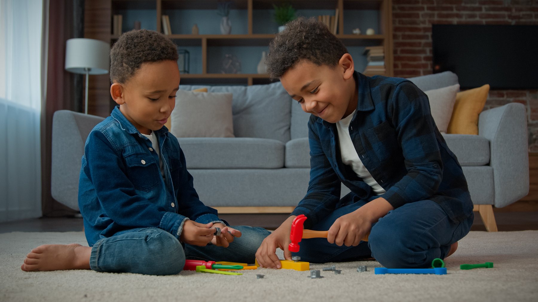 Two young boys playing together with a toy construction set